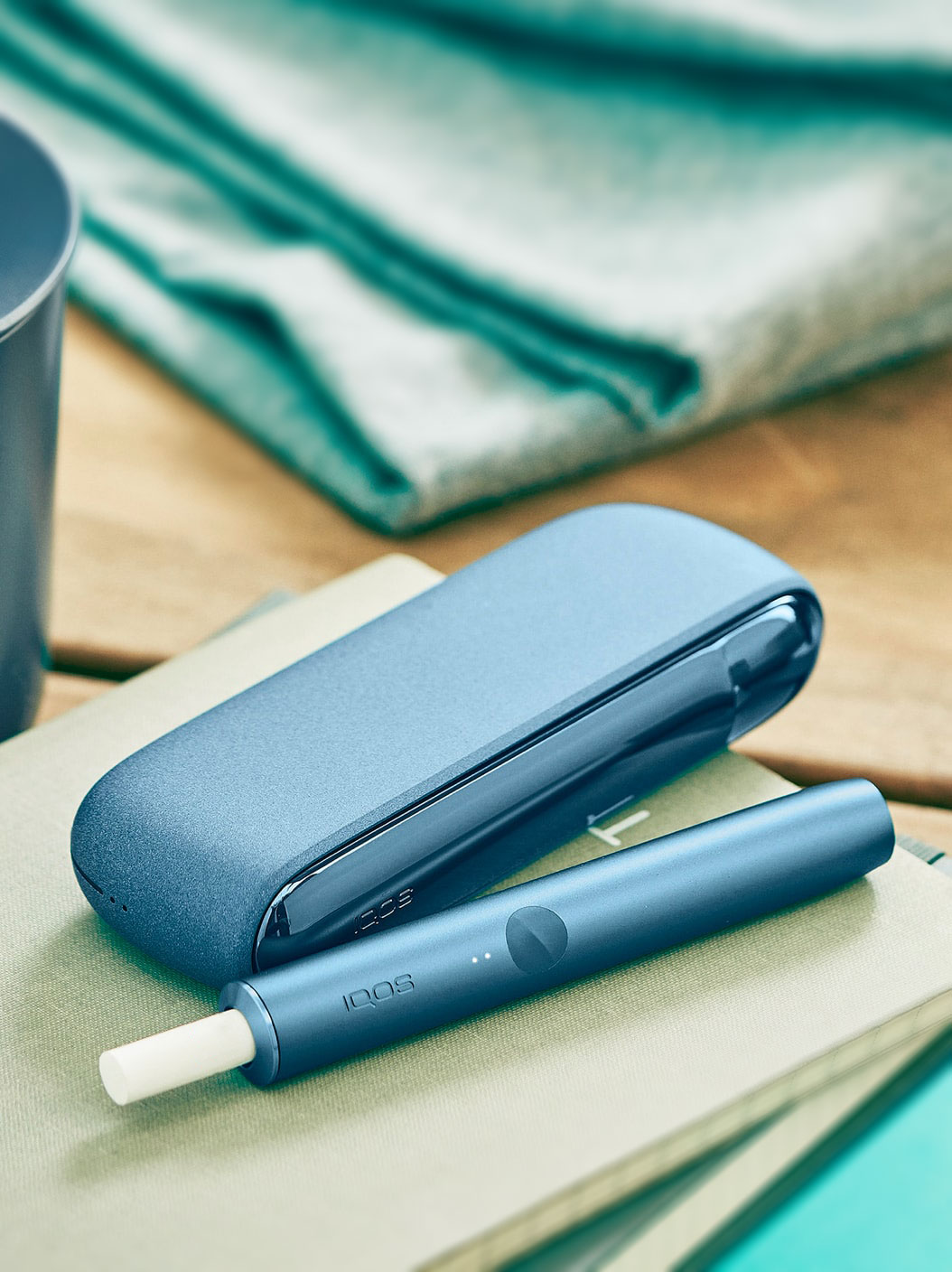 An Azure Blue IQOS ILUMA Holder and Pocket Charger. 