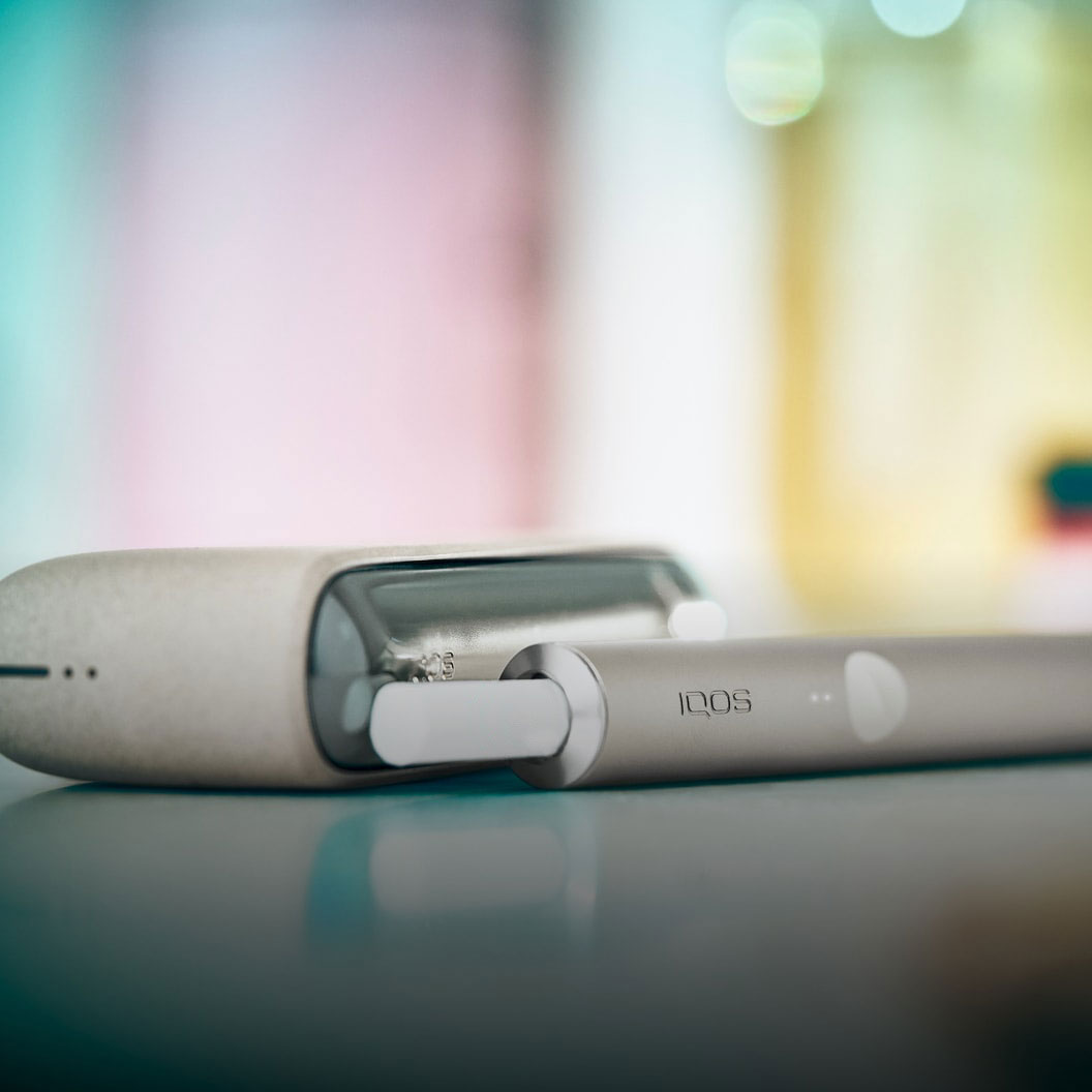 A Taupe IQOS ILUMA Holder and Pocket Charger covered with a sleeve.