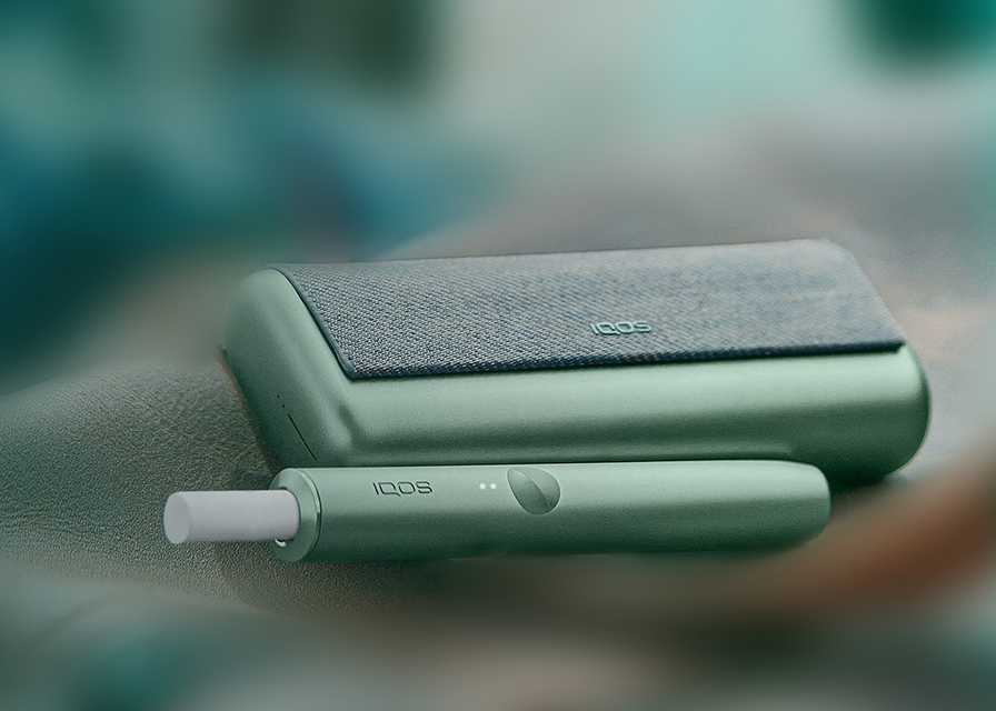 Close up of an IQOS ILUMA jade green device.