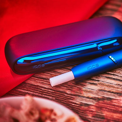 IQOS 3 DUO de couleur bleu stellaire avec un bâtonnet HEETS sur une table